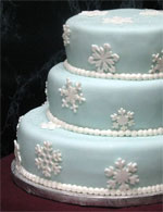 Small icy blue stacked fondant wedding cake with white snowflakes