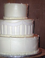 Stacked wedding cake in buttercream and rolled fondant.