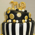 Whimsical graduation cake in gold and black rolled fondant.
